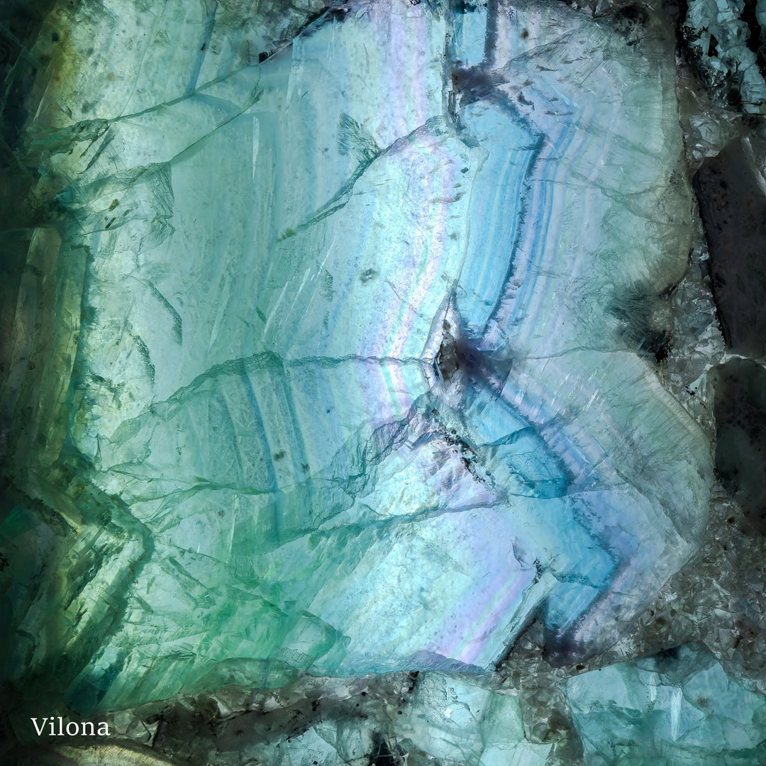 Fluorite wall panel pair showing blue-green swirls and dark fissures in the crystal