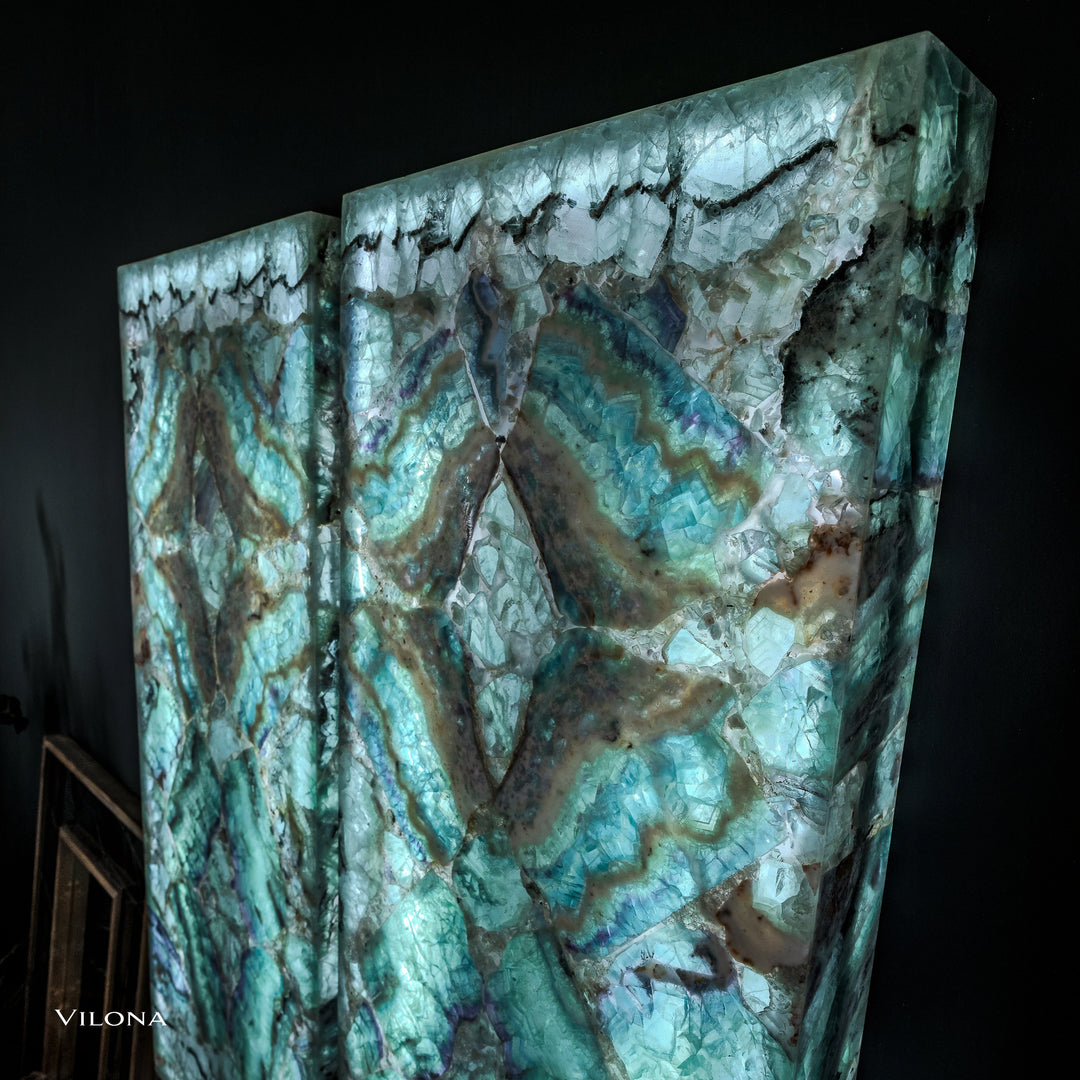 Two teal fluorite crystal wall panels with large centered star motif and glossy stone texture.