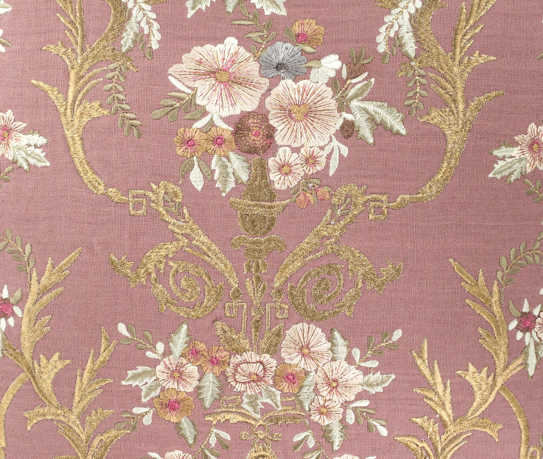Close-up embroidery detail: mauve linen with cream and pink flowers and gold vine scrolls