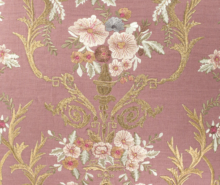 Close-up embroidery detail: mauve linen with cream and pink flowers and gold vine scrolls