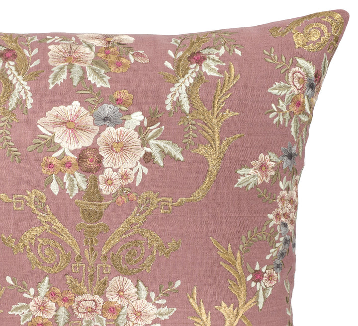 Close-up of mauve embroidered linen pillow cover with cream floral blossoms and gold vines