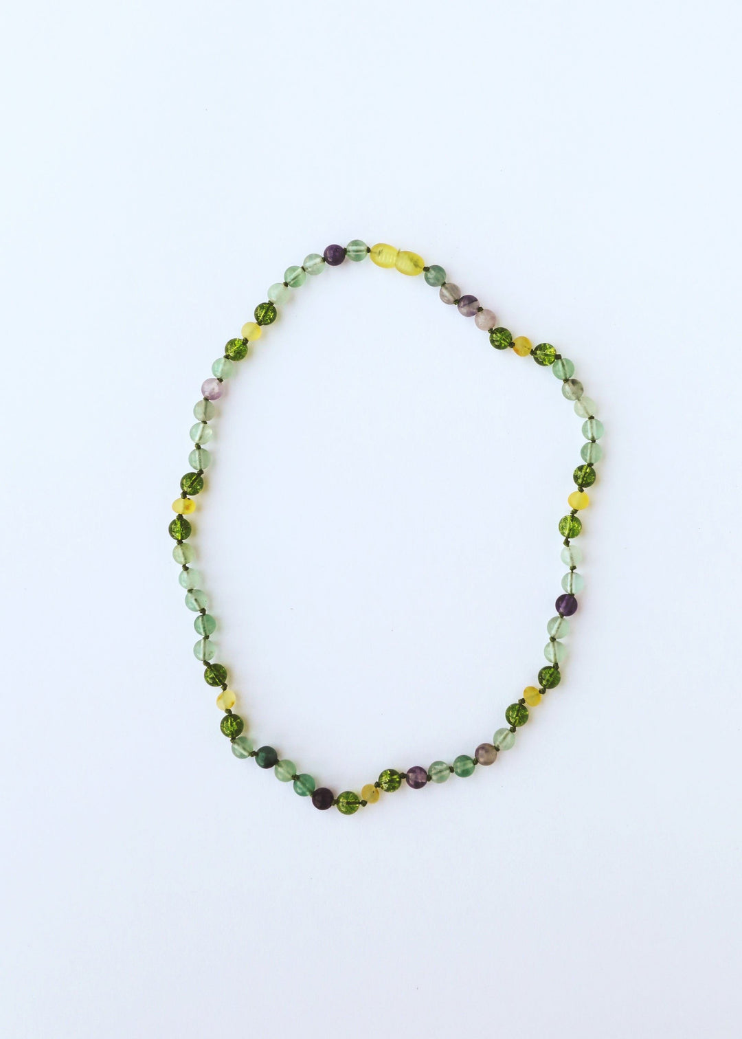 Gemstone bead necklace with green, yellow, and subtle purple beads in an oval loop