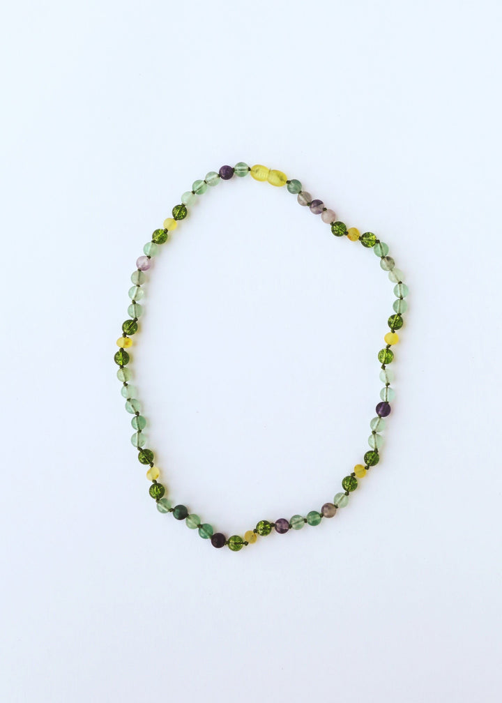 Gemstone bead necklace with green, yellow, and subtle purple beads in an oval loop