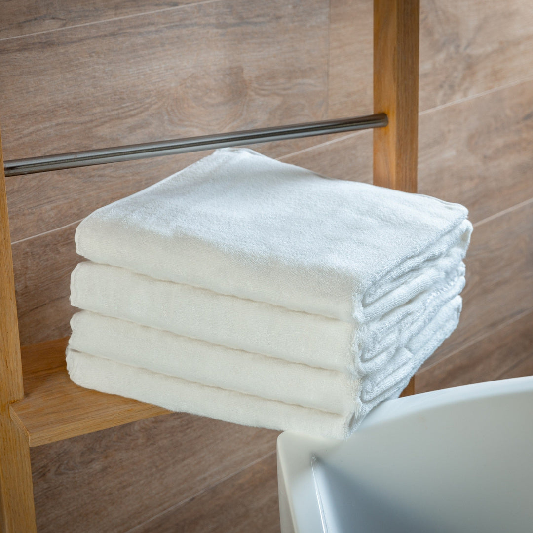 White bath towels stacked neatly, folded edge visible
