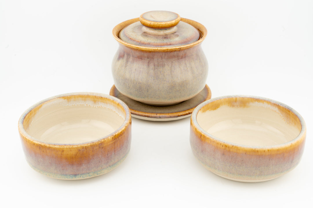Beige glazed gaiwan with lid and two matching cups in front.
