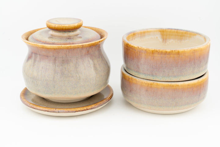 Beige glazed gaiwan with lid and two matching cups, all with orange rim glaze.