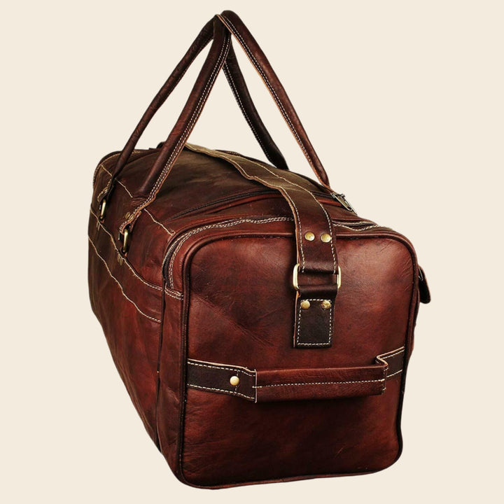 Brown leather duffel bag side view with top handles and stitched trim