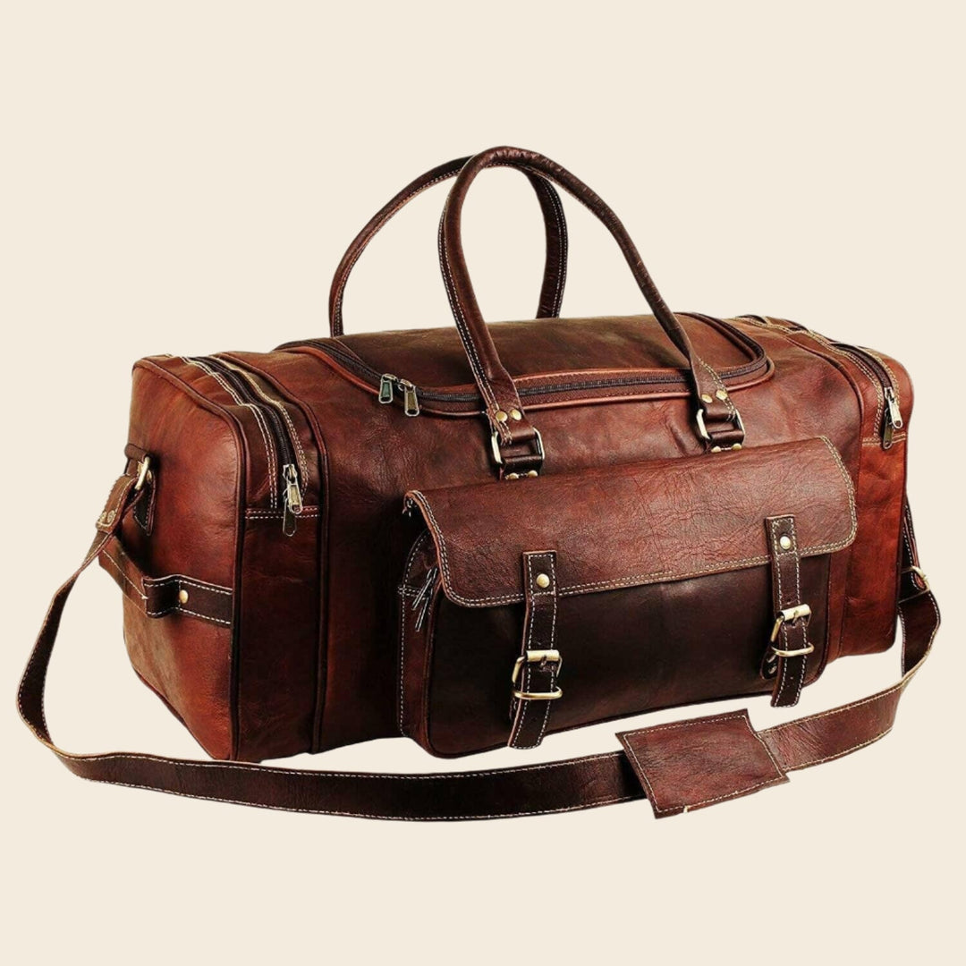 Brown leather duffel bag with top handles, front pocket, and adjustable shoulder strap