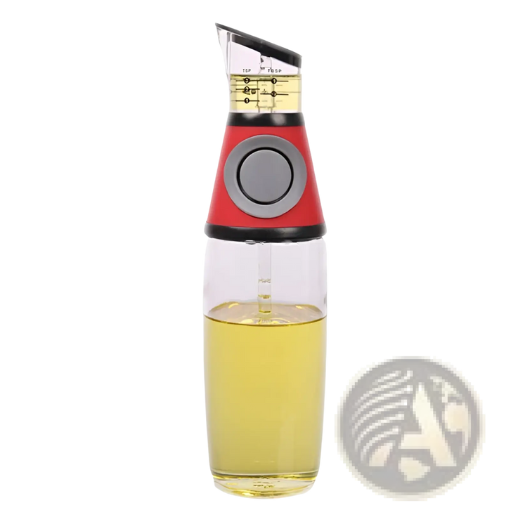 Glass oil dispenser with red base, clear body, and precision measuring cup for yellow oil.