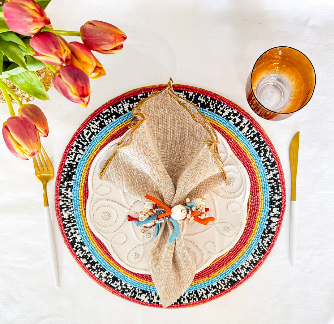 Beige linen napkin with gold ruffled edge, folded centerpiece