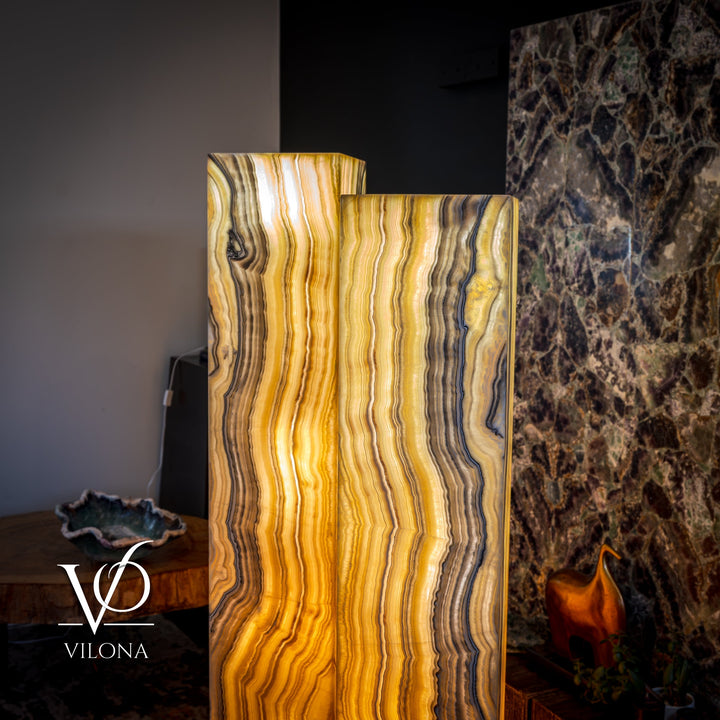Close view of onyx floor lamp shade with glowing amber light and square top