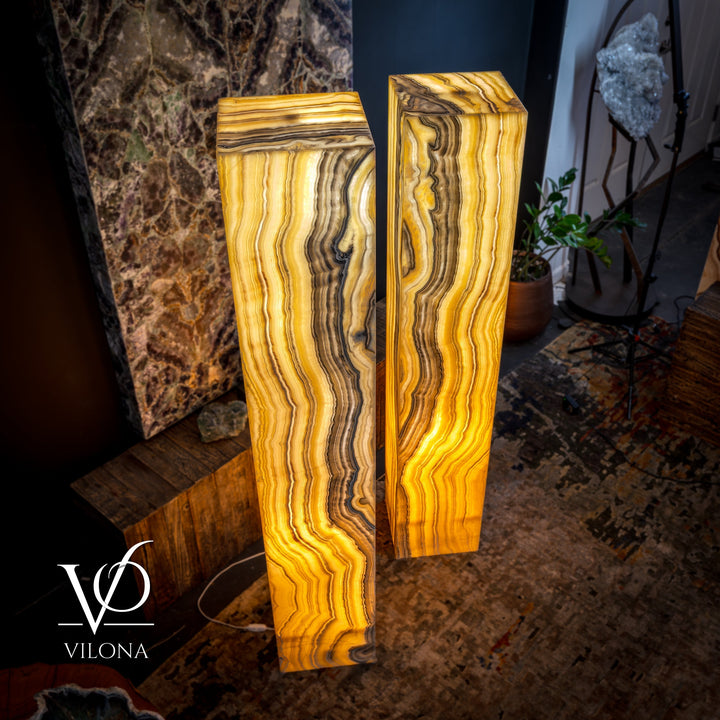 Pair of tall onyx floor lamps, glowing amber light inside rectangular square-top shades