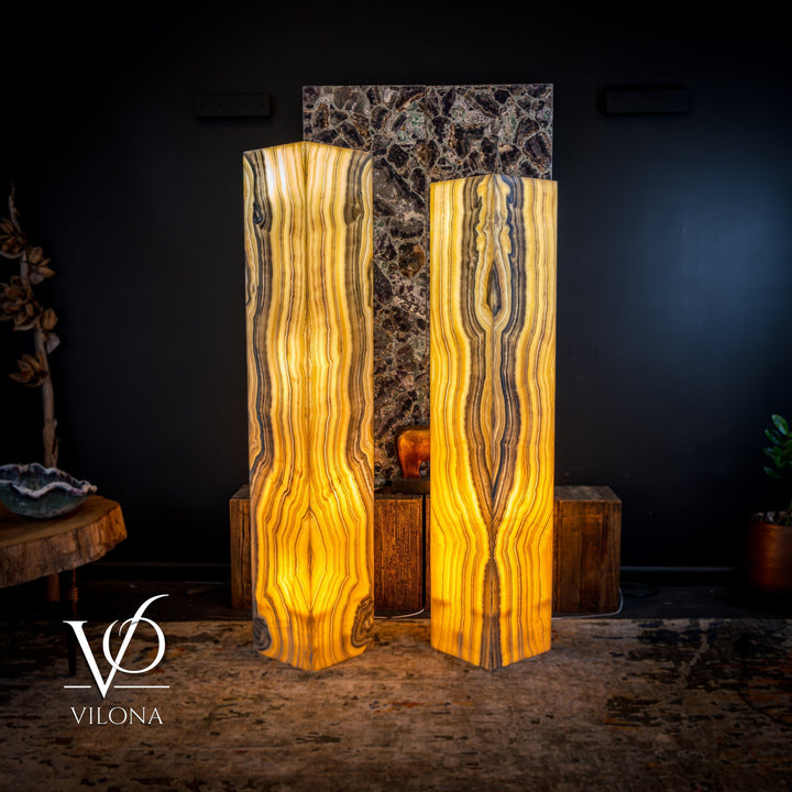 Pair of large onyx floor lamps with glowing amber light and vertically striped square shades
