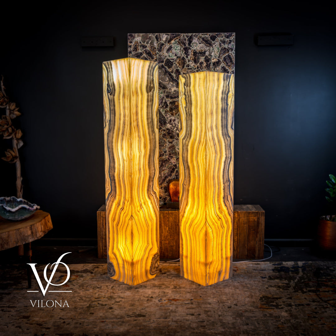 Two large onyx floor lamps with warm amber glow and vertical ribbon-like veining