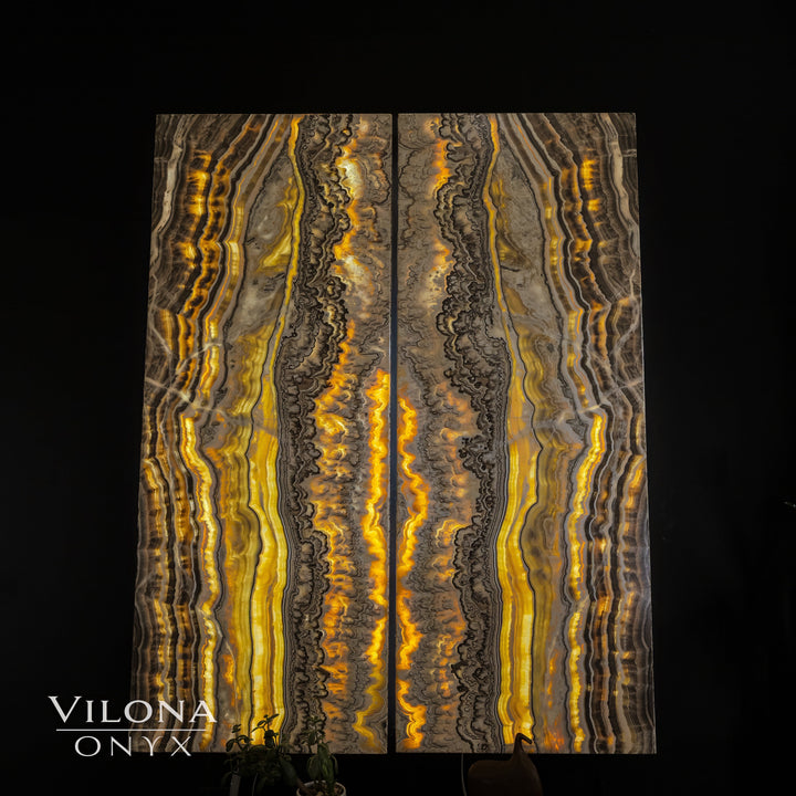 Onyx wall panel showing golden vertical striations on gray stone with bright accents.