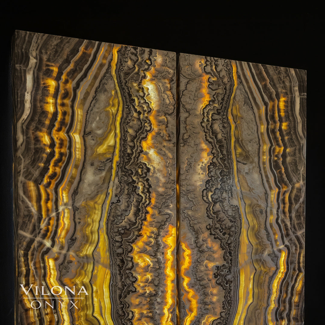 Onyx wall panel featuring alternating dark and gold vertical bands with a glowing center.