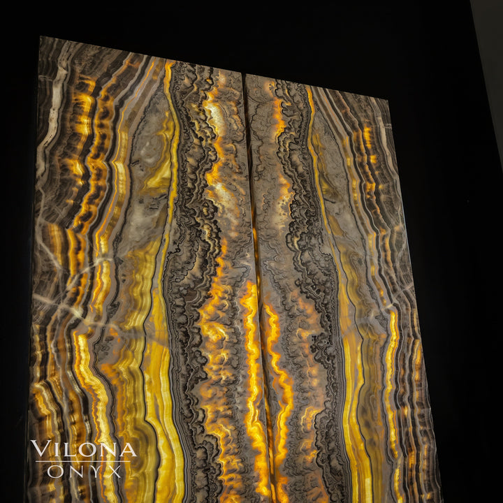 Onyx wall panel with golden and gray vertical patterns and bright center highlights.