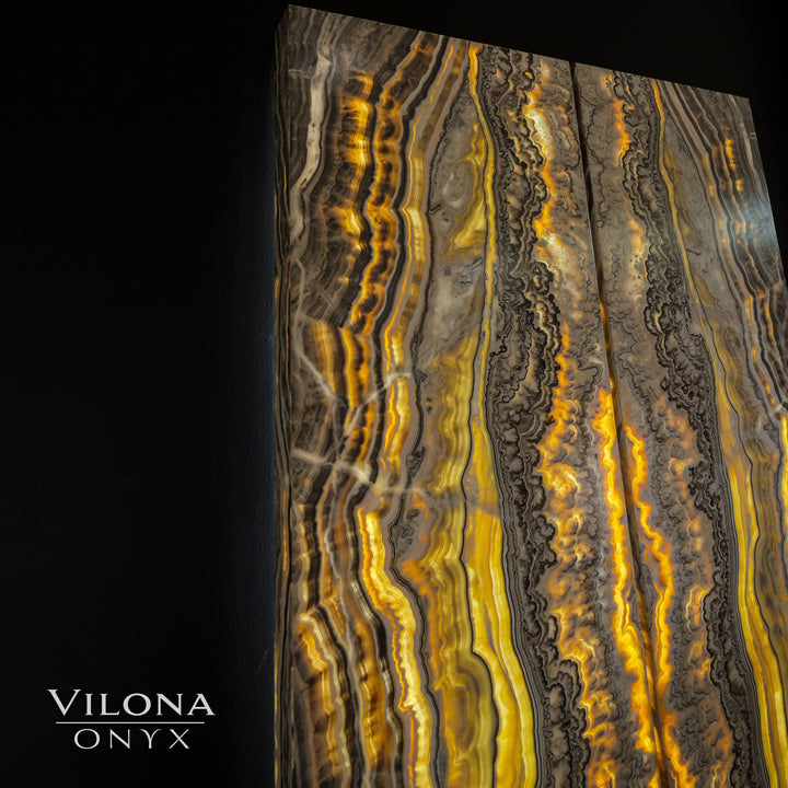 Onyx wall panel with tall vertical amber, gold, and gray ribbon-like onyx patterns.
