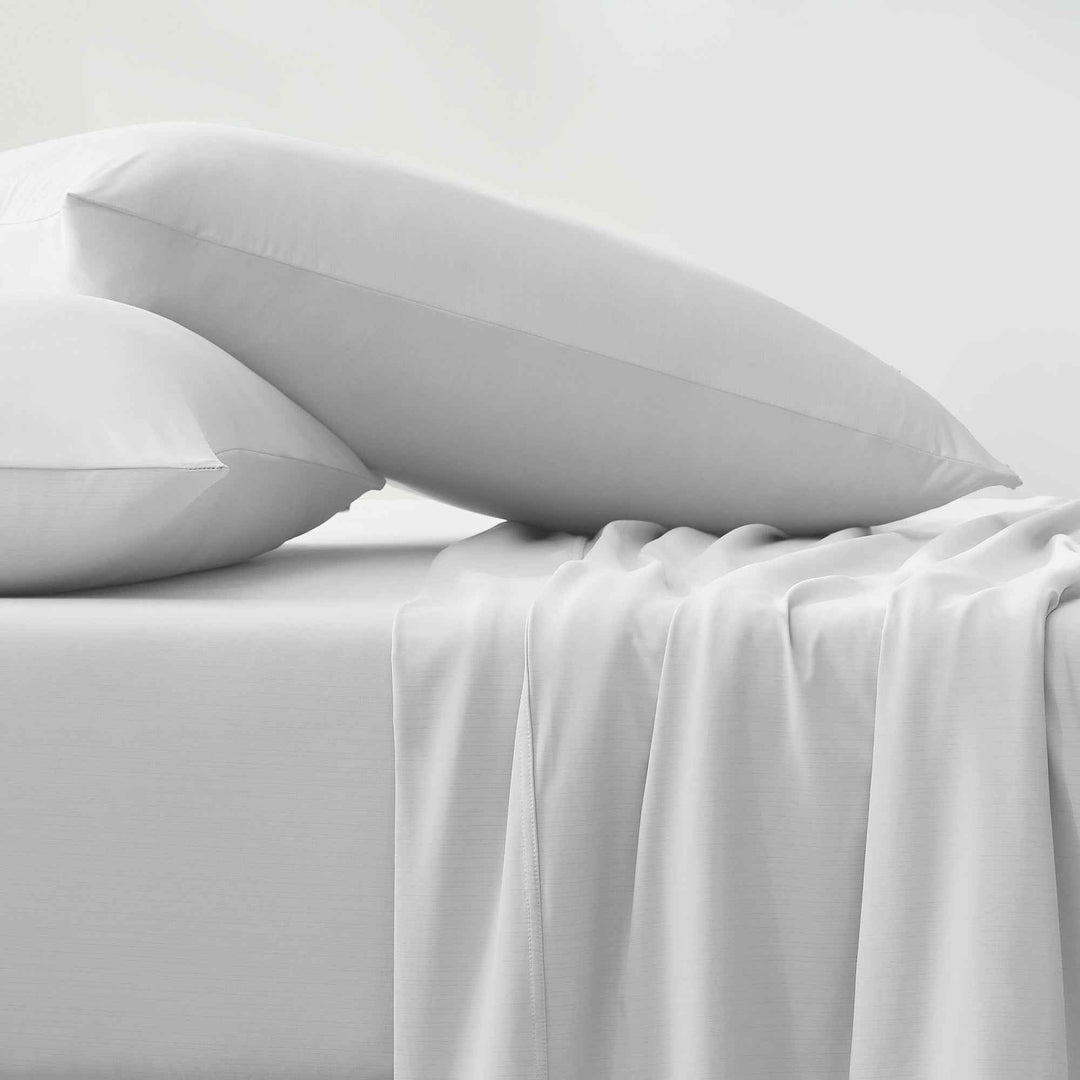 White pillowcases and sheet with layered folds and soft, smooth surface