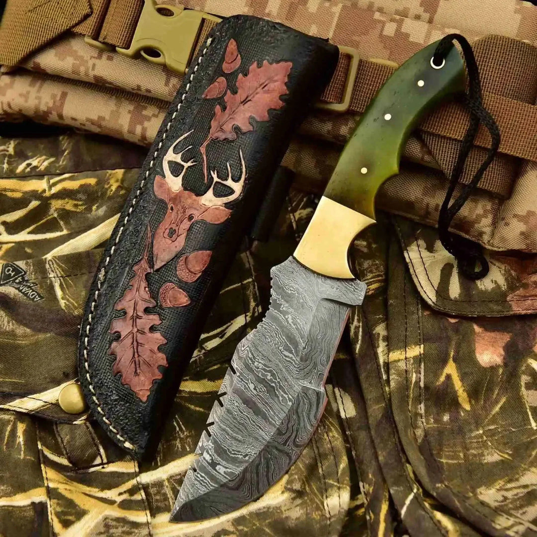 Survival knife with damascus blade, green handle, and black sheath with deer motif
