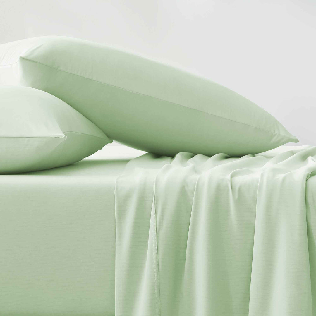 Folded light green fitted and flat cooling sheets with smooth surface