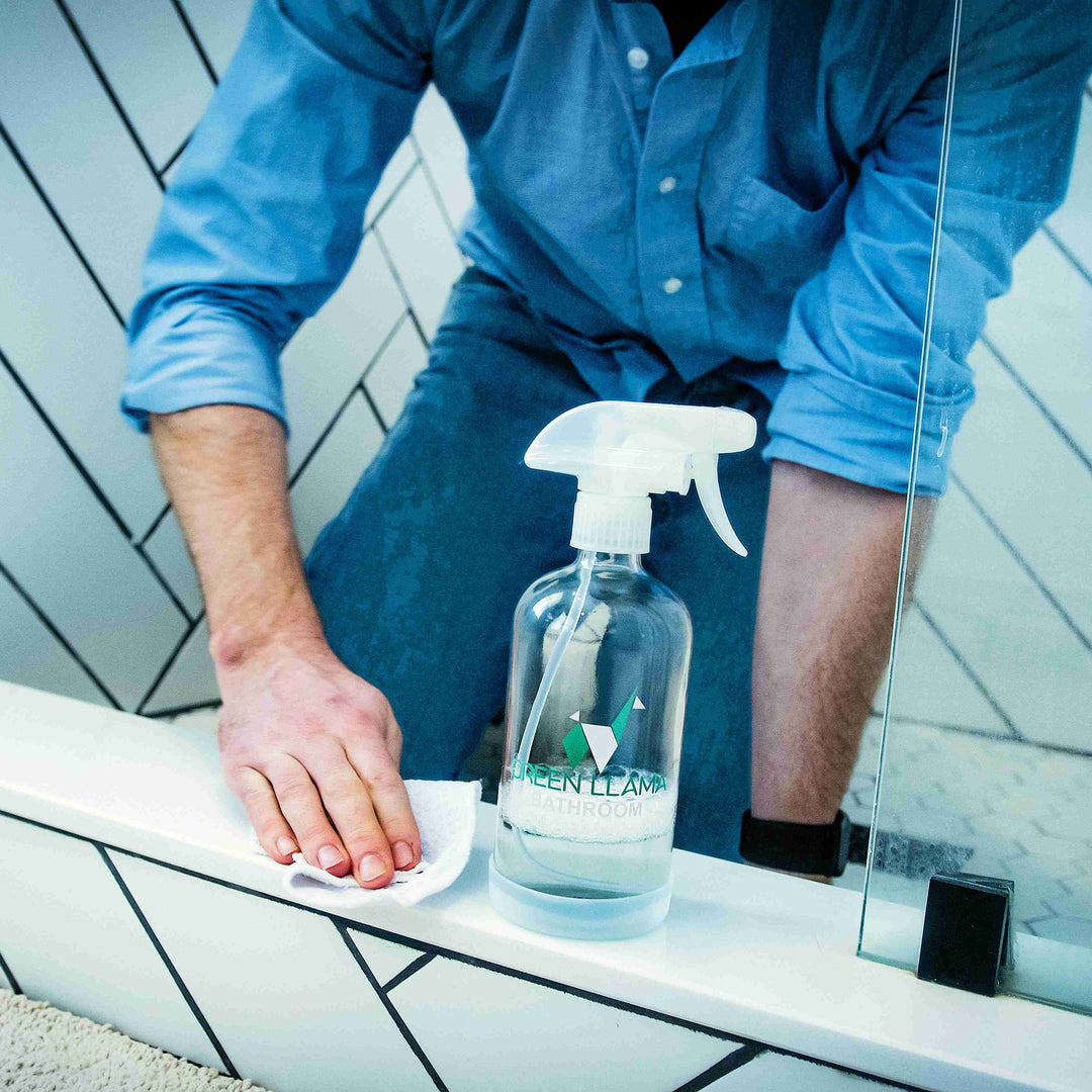 Green Llama bath room one-surface cleaner refill bottle near sink and tiled counter