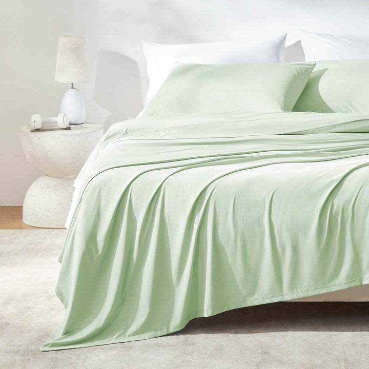 Light green cooling sheet set on a bed with fitted sheet and flat top sheet