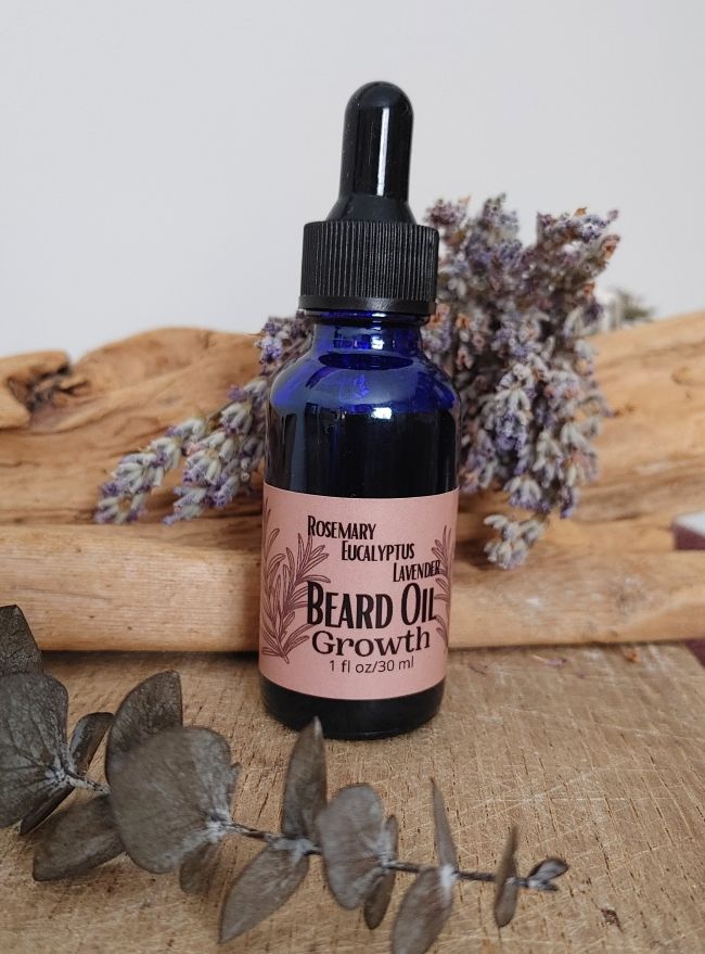 Blue glass beard oil bottle with black dropper and pink &