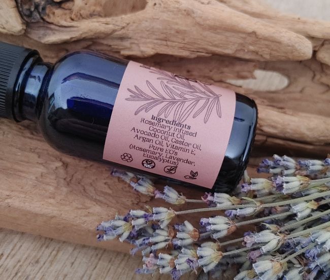 Blue glass beard oil bottle with black cap and pink ingredient label on the back