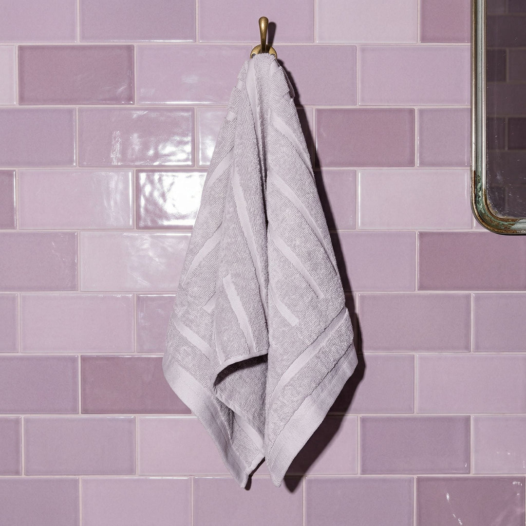 Lilac cotton hand towel hanging, textured loop pile with stitched stripe detail