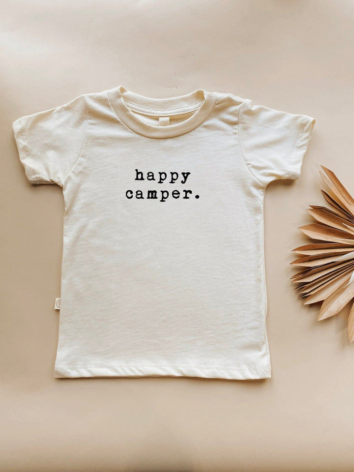 Toddler short-sleeve crewneck T-shirt in light cream with centered 'happy camper.' print