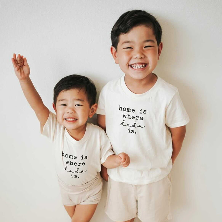 Kids organic T-shirt in cream with 'home is where dada is' print on two children.