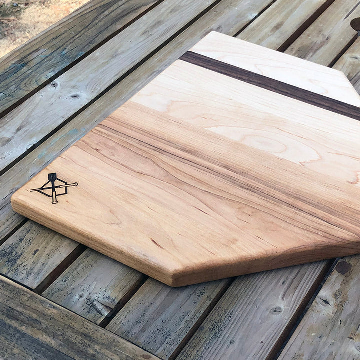 Home plate cutting board, light wood with dark grain strip and beveled edge, engraved logo