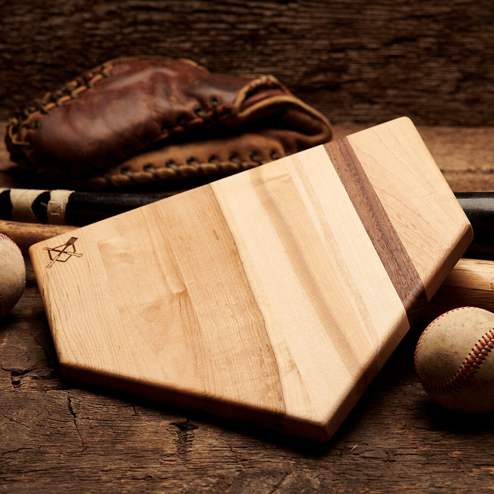 Home plate cutting board, light wood with dark stripe, engraved crossed logo on side