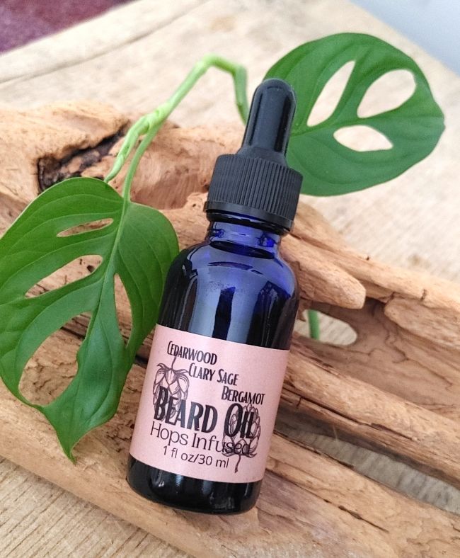 Hydrating beard oil bottle with black dropper cap, blue glass, &