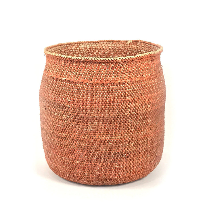 Large woven basket in rust-brown with stitched braided edge, open top