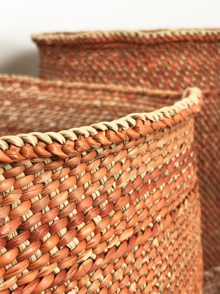 Closeup of rust-brown woven basket weave with cream braided rim edge