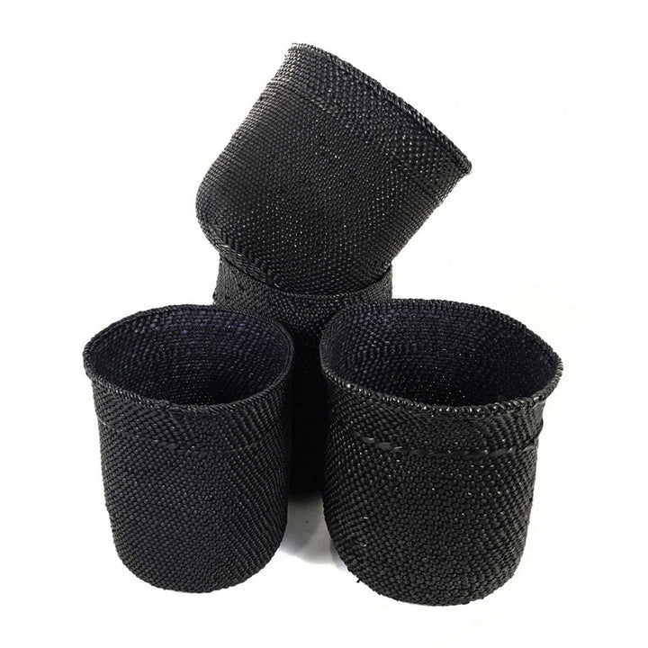 Three small dark woven baskets, with one upright and two nested together