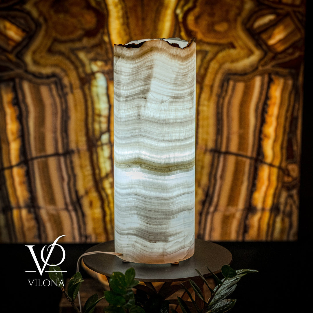 White onyx table lamp with translucent ribbed pattern, cylindrical shade on black round base