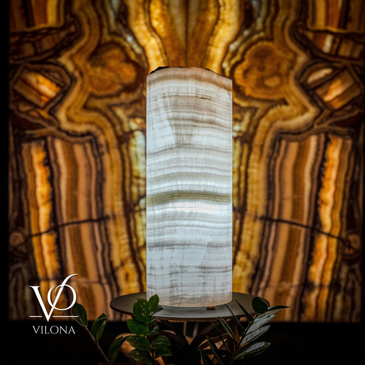 Tall white onyx table lamp with cylindrical shade, irregular top, on black round base