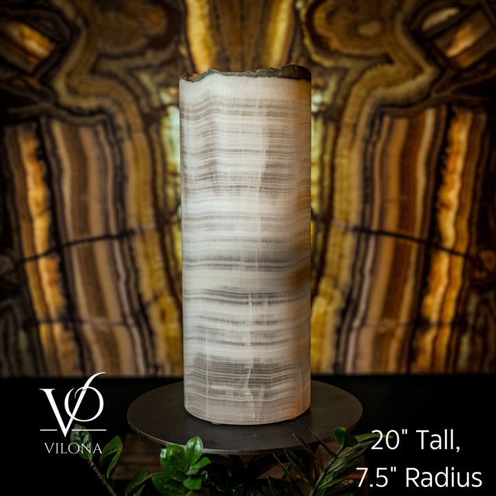 Table lamp with tall cylindrical onyx shade; ribbed white veining, on round black base