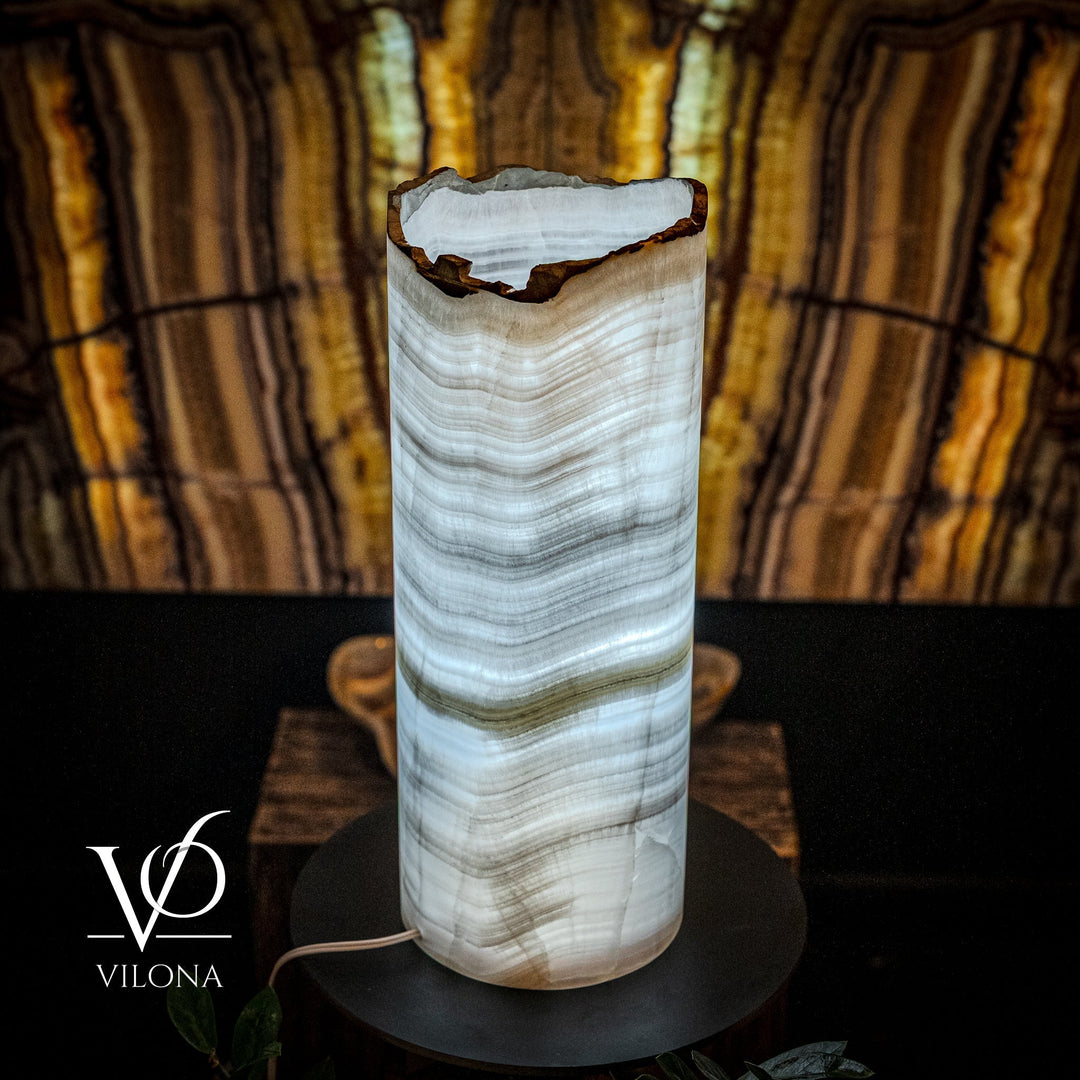 Onyx table lamp showing live-edge top of translucent cylinder shade on black base