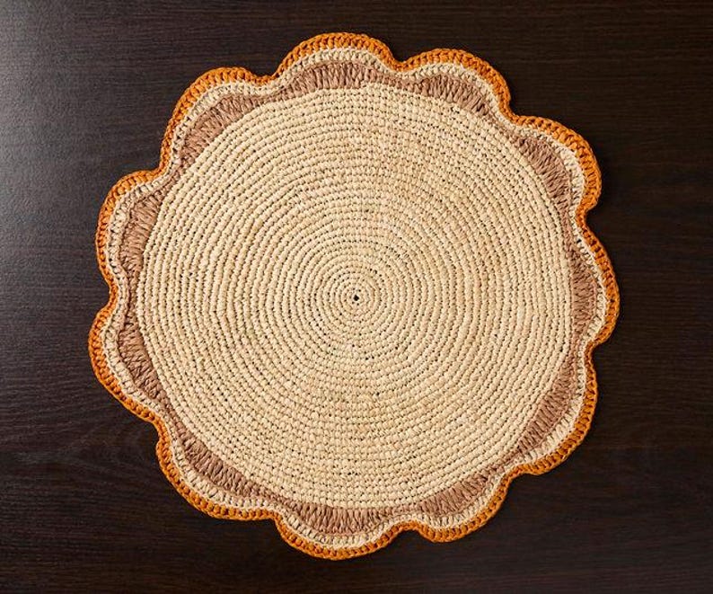 A handwoven Raffia Placemat in Tan, Orange & Brown