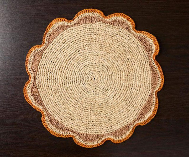A handwoven Raffia Placemat in Tan, Orange & Brown