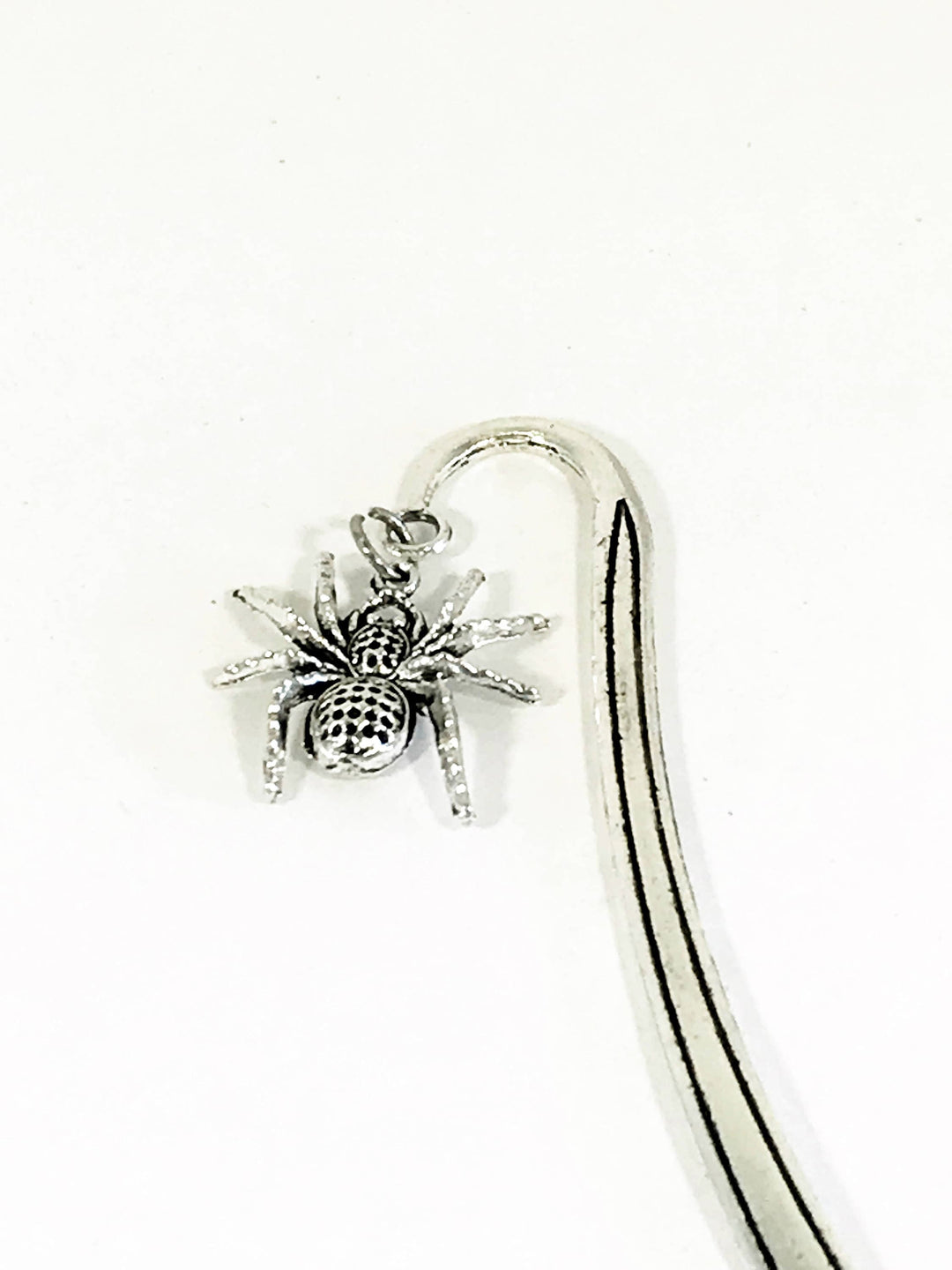 Spider charm bookmark detail: arched silver clip with small spider ornament