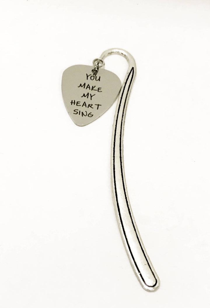 Heart-shaped guitar pick bookmark with 'You make my heart sing' text and long silver back