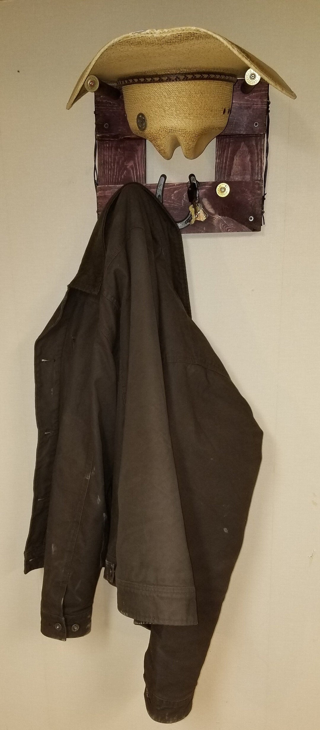 Horizontal wall-hanging western organizer with tan top pocket and black coat hanging