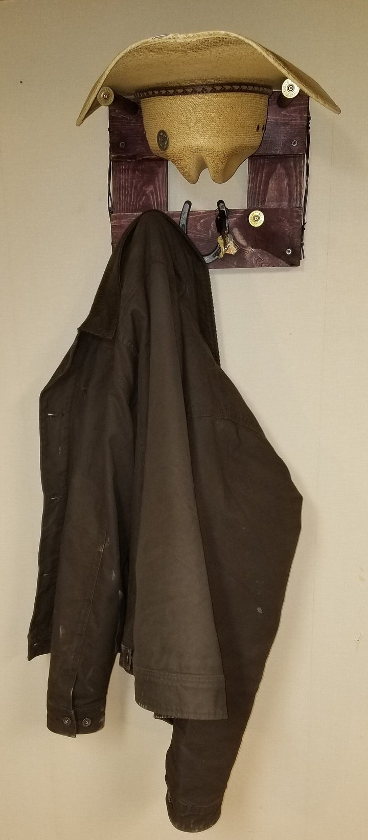 Horizontal wall-hanging western organizer with tan top pocket and black coat hanging