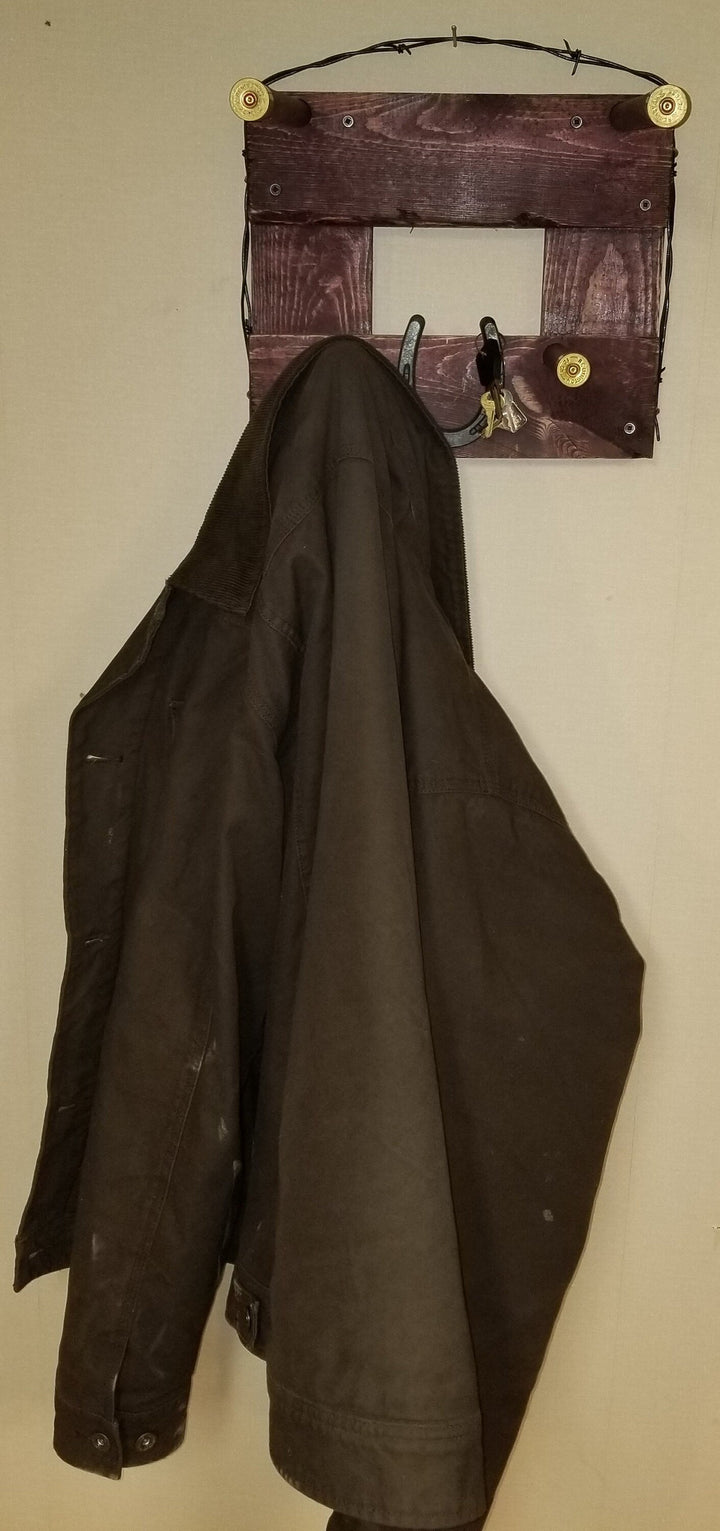 Horizontal wall-hanging western organizer with tan top pocket and black coat on dark panel