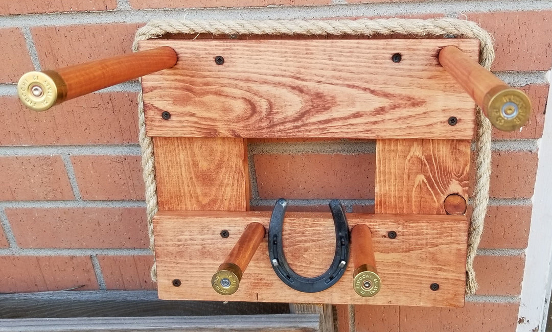 Wall organizer board with rope hanger and black U-shaped hooks on light wood